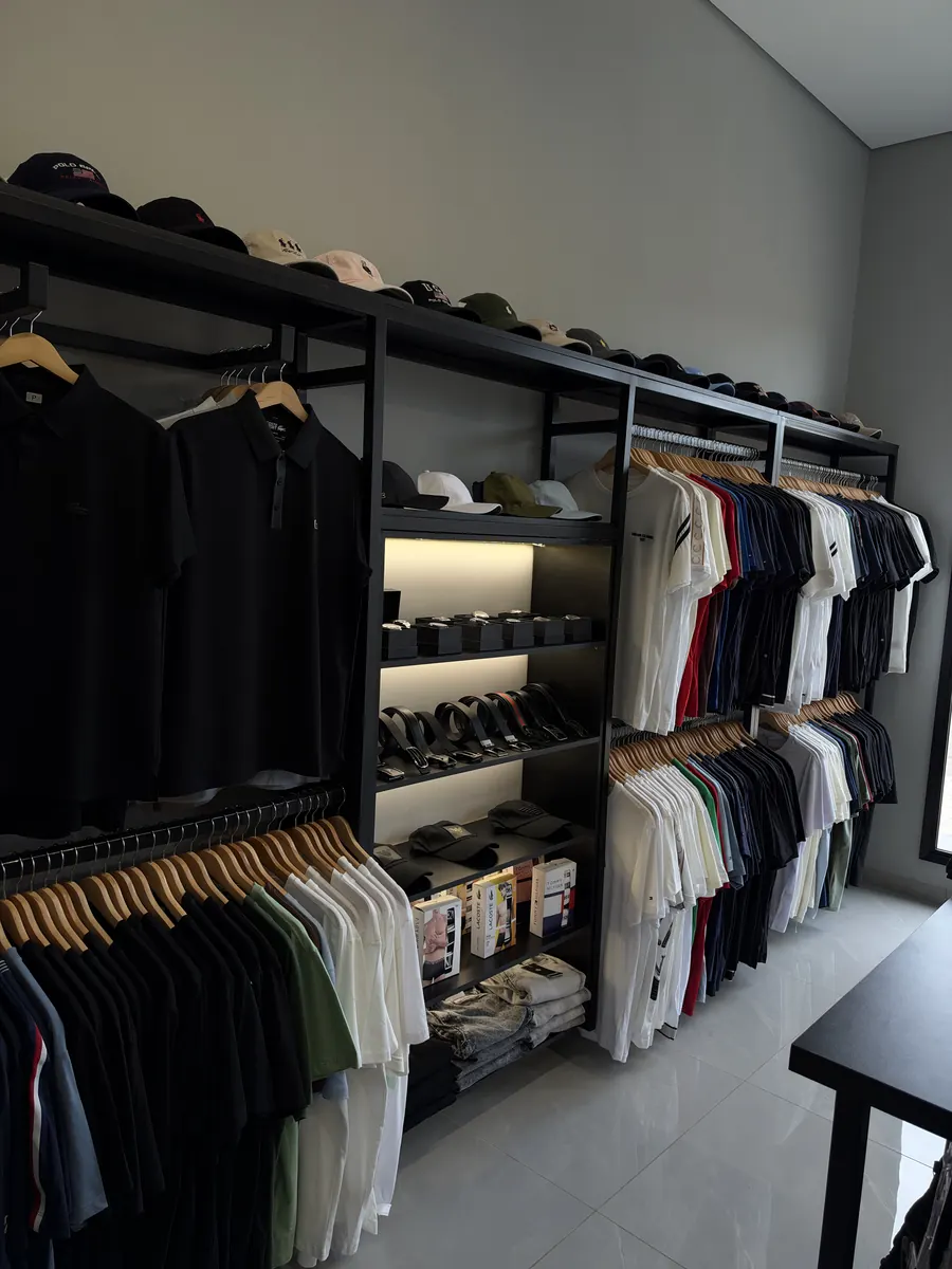 Estante com bonés, relógios, cintos e camisetas